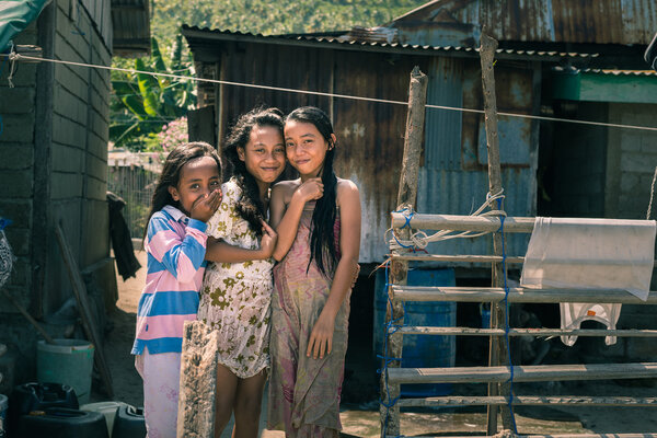 Smiling cute young girls in slum, Indonesia