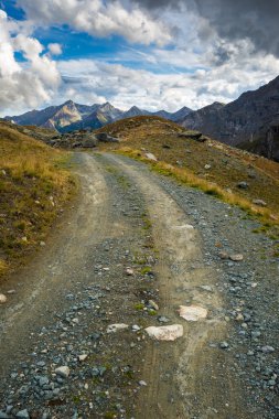 Toprak yol doğal Alp Peyzaj ve dramatik gökyüzü