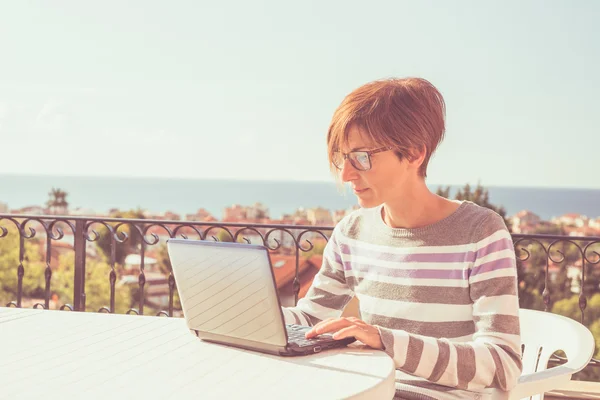 Kvinna som arbetar hemma med netbook utomhus — Stockfoto