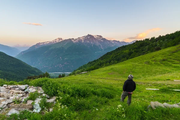 Один чоловік, спостерігаючи Схід сонця високо в Альпах — стокове фото