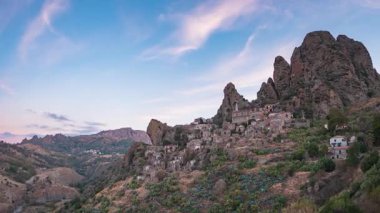 Zaman aşımı: İtalya 'nın Pentedattilo Calabria antik köyü gündoğumunda kayalık dağ yamacına inşa edilmiş dramatik kayalıklar ve tarihi taş evler mirası ve Akdeniz kültürünü sembolize ediyor.