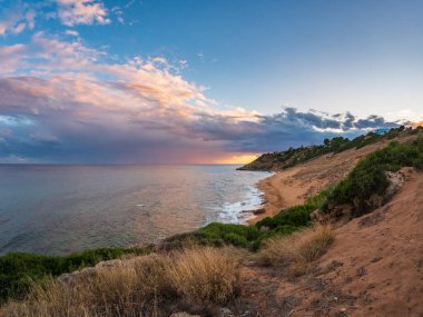 Le Cannella Capo Rizzuto Calabria 'nın altın kumlu plajı turkuvaz suları, kayalık kıyı şeridi ve günbatımı gökyüzü özgürlük, doğa huzuru ve Akdeniz yaz cazibesini simgeliyor..