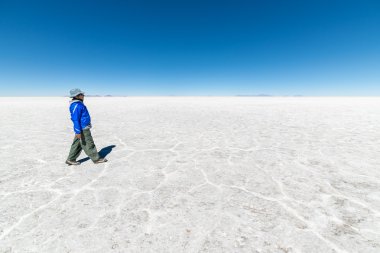 Tourist walking on Uyuni Salt Flat, Bolivia clipart