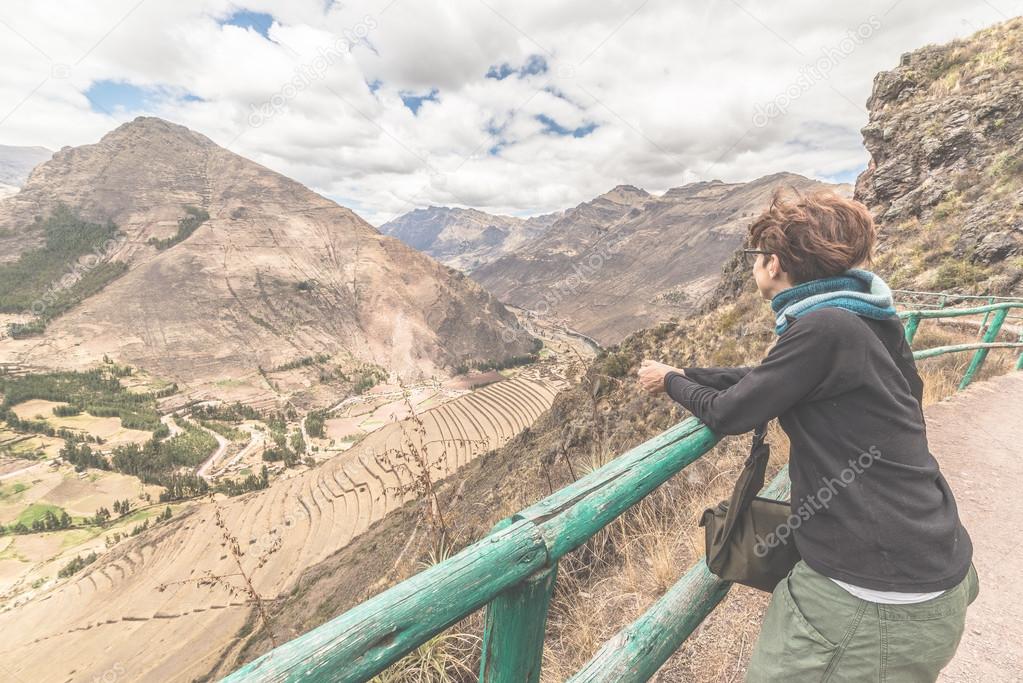 Tourist looking at Inca terraces of Pisac, Peru, filtered image