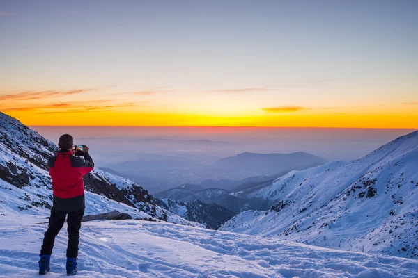 Hegymászó (alpinista) figyelembe véve a selfie a hegy csúcs Twilight — Stock Fotó