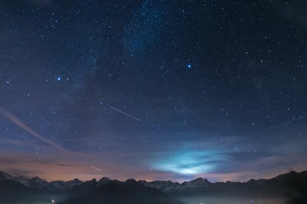 Nuit dans les Alpes sous le ciel étoilé et la lune Photo De Stock