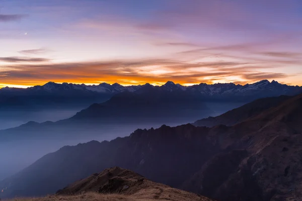 Гірський силует і приголомшливе небо з місяцем на заході сонця — стокове фото
