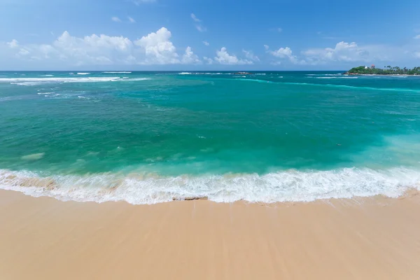 Playa tropical dorada y azul verde ondeando océano — Foto de Stock