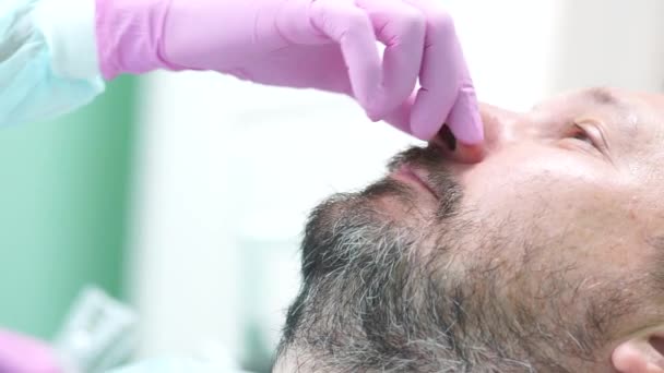 Medelålders man med mustasch och skägg på tandläkarens utnämning — Stockvideo