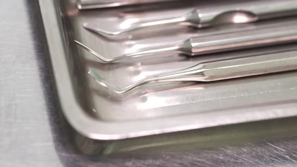 Dental instruments lie in a metal stand close-up — Stockvideo