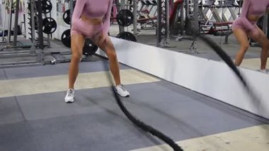 Genç ve güzel kız salonda iplerle meşgul.