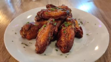 Beyaz bir tabakta kızarmış tavuk kanadı yakın.