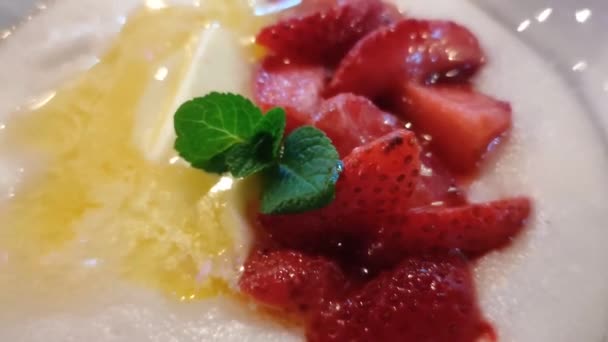 Porridge di semolino con frutta e menta in un piatto bianco — Video Stock