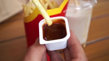 Kafede barbekü sosuna batırılmış yakın plan patates kızartması.