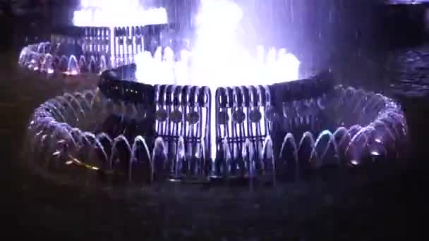 Fuente iluminada en la plaza de la ciudad por la noche — Vídeo de stock