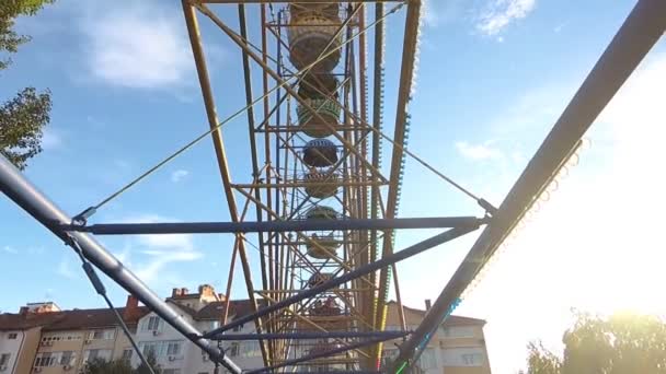 Parte de las atracciones. Rueda de la fortuna en verano en un día soleado — Vídeo de stock