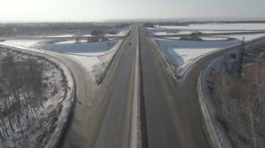 Güneşli bir günde, kışın hareket halindeki arabalarla bir yol kavşağının hava fotoğrafçılığı