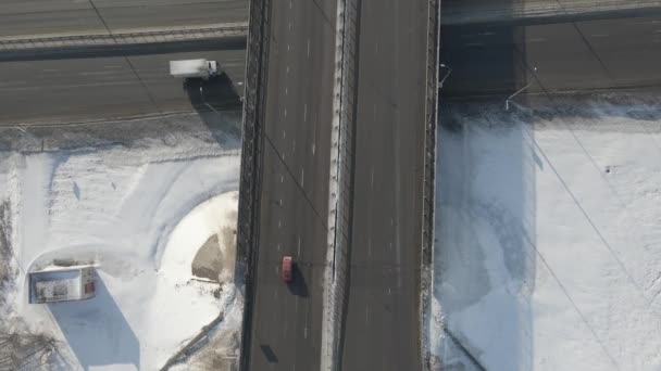 Fotografía aérea de un cruce de carreteras con coches en movimiento en invierno en un día soleado — Vídeo de stock