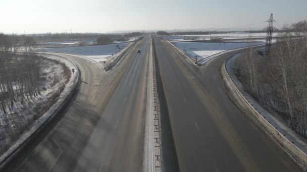 Flygfoto av en vägkorsning med rörliga bilar på vintern på en solig dag — Stockvideo