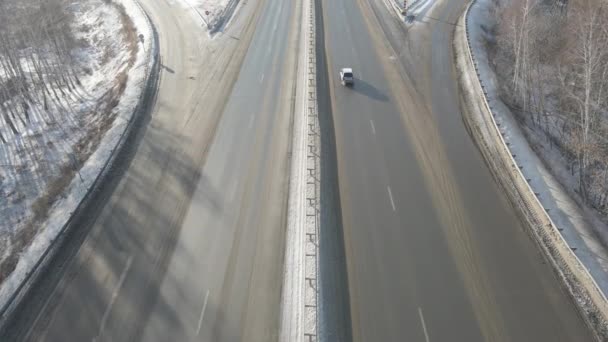 Fotografia lotnicza skrzyżowania dróg z poruszającymi się samochodami zimą w słoneczny dzień — Wideo stockowe