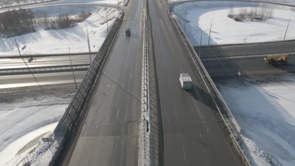 Fotografía aérea de un cruce de carreteras con coches en movimiento en invierno en un día soleado — Vídeo de stock