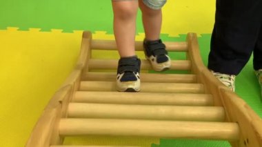 Çocukların mavi spor ayakkabılı bacakları özel bir simülatörün üzerinde hareket ediyor.