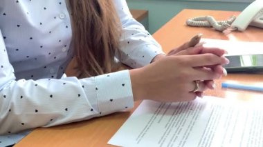 Açık renk bluzlu, hafif manikürlü ve yakın plan altın yüzüklü bir kızın elleri.