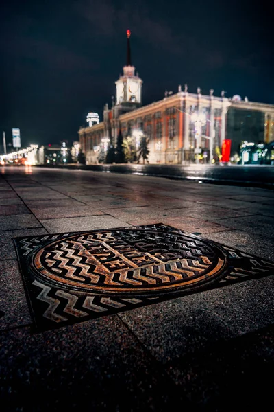 Администрация Екатеринбурга с канализационным люком ночью — стоковое фото