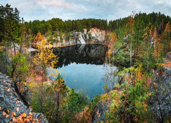 秋の紅葉と青い空の美しい山の湖の周りの落ち葉はまだ水に反映されます 高品質の写真 ロイヤリティフリーのストック画像