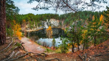 Sonbahar renkleri ve düşen yapraklar güzel dağ gölünün etrafında durgun suya yansıyan mavi gökyüzü. Yüksek kalite fotoğraf