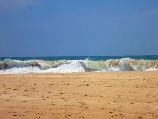 Порожній океанський пляж з жовтим піском і піщаними хвилями — стокове фото