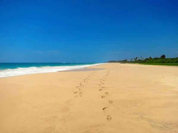 Couple barefoot at empty sandy beach — Stock Photo, Image