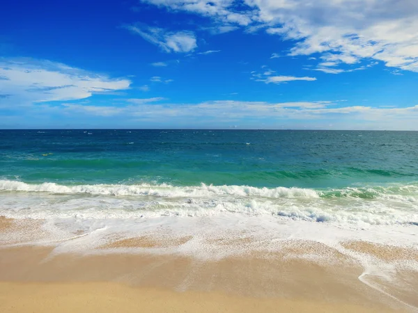 Спокійний тропічний пляж з білим піском і бірюзовою водою під блакитним хмарним небом — стокове фото