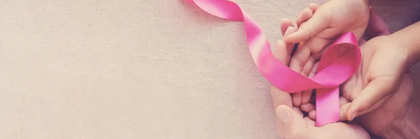ピンクリボンを持つ大人と子供の手 乳がんの意識 10月ピンク 世界がんの日 — ストック写真
