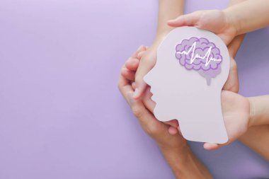 Yetişkin ve çocuk elleri ansefalografi kağıdı kesiği, otizm, felç, epilepsi ve alzheimer farkındalığı, nöbet bozukluğu, felç, hiperaktiflik, dünya akıl sağlığı günü konsepti