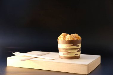 Bir fincan kahve ve ahşap masada bir pasta..