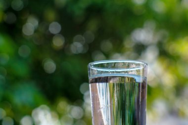 Arka planda bir bardak içme suyu var.