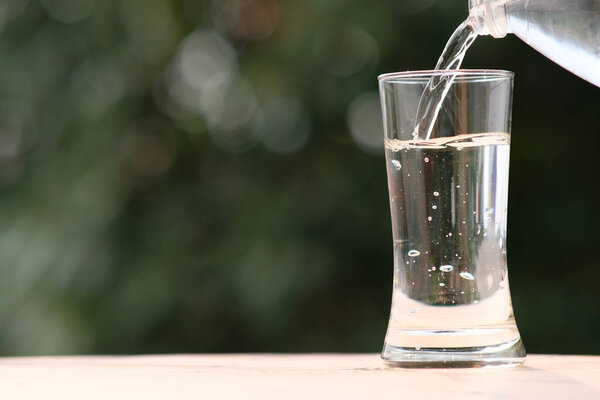 минеральная питьевая вода на деревянном столе и вода в стекле