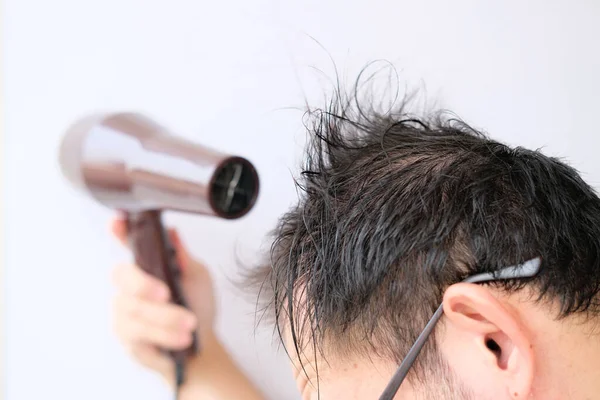man with hair dryer on white background