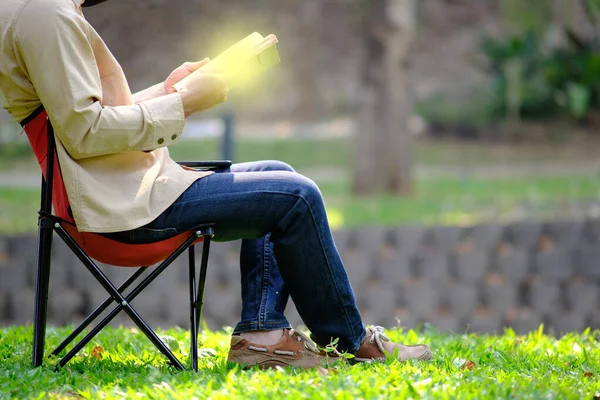 Person reading a book in the garden and relaxing on holiday