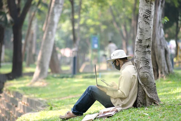 man using laptop computer in garden background and technology concept