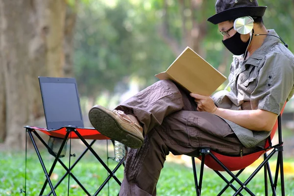 Man using laptop computer in garden background and relaxing on holiday