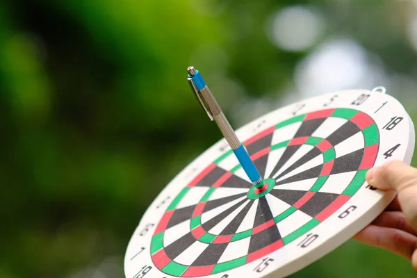 Businessman hand working on table and dart board with target and business growth concept