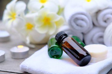 Ahşap zemin üzerinde mumlar olan beyaz havlu. Mumlarla aydınlatılmış masaj seti. Mum ışığında masaj terapisi. Güzellik spa tedavisi ve rahatlama konsepti