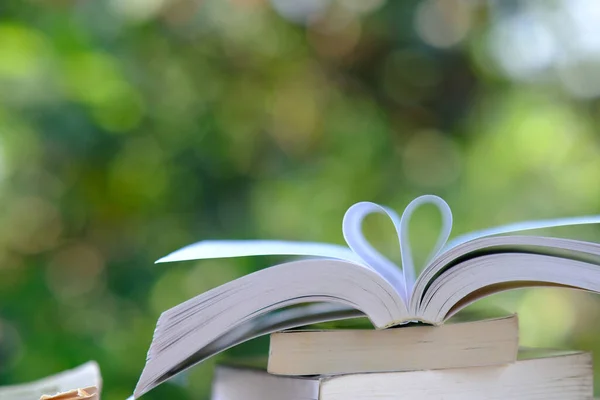Tahta masadaki kitaplar ve eğitim öğrenme konsepti, kütüphanede açık kitap veya ders kitabı, masanın üzerine yığılmış kitap yığınları