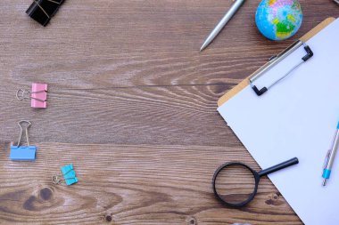 Ahşap masa arkaplanındaki ofis malzemeleri