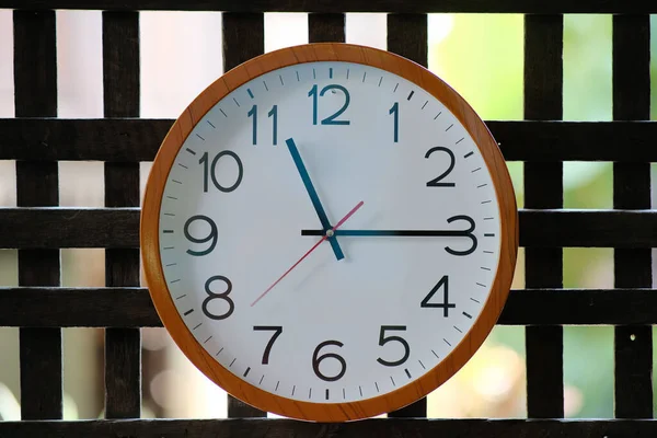 Wall clock on wood background and time concept