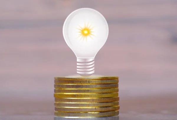 Light bulb with money on table and saving money concept, business financial and saving money investment, Advertising coins of finance and banking