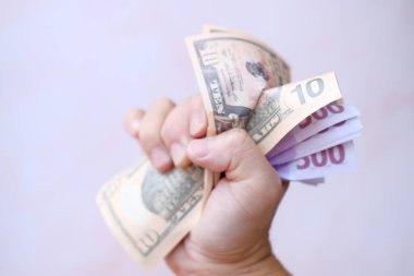 hand holding a bunch of dollars on a white background 