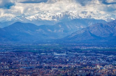 Arka planında Susa Vadisi 'nin karla kaplı zirveleri olan Torino şehrinin hava manzarası, Piedmont, İtalya
